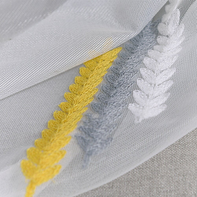 Visillo bordado con motivo geométrico.